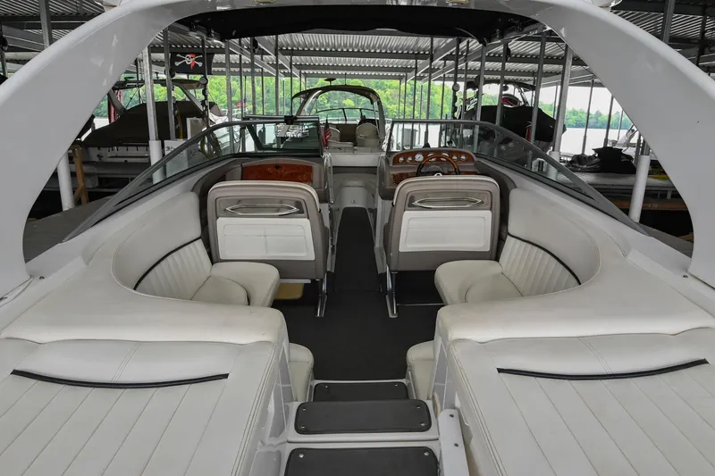 Slide: The Image of 2005 Cobalt 262 boat interior with white seating and sleek design in a covered dock. - 10