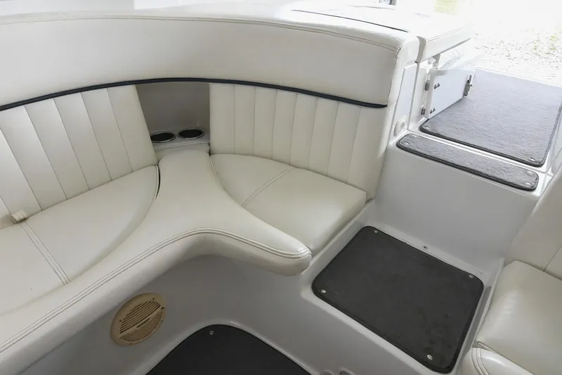 Slide: The Image of 2005 Cobalt 262 boat interior with white cushioned seating and cup holders. - 15