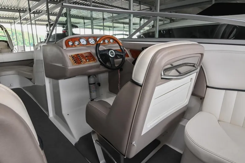Slide: The Image of 2005 Cobalt 262 boat interior with steering wheel and dashboard in a covered dock. - 25