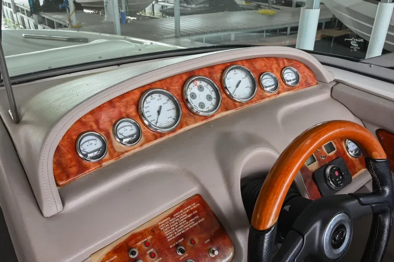 Slide: The Image of Dashboard of a 2005 Cobalt 262 boat with wood accents and multiple gauges. - 28