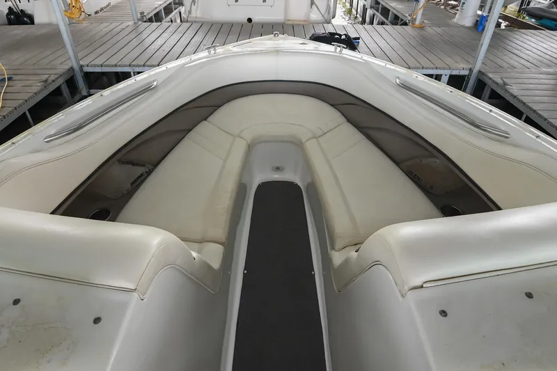 Slide: The Image of 2005 Cobalt 262 boat interior with white seating and wooden dock background. - 32