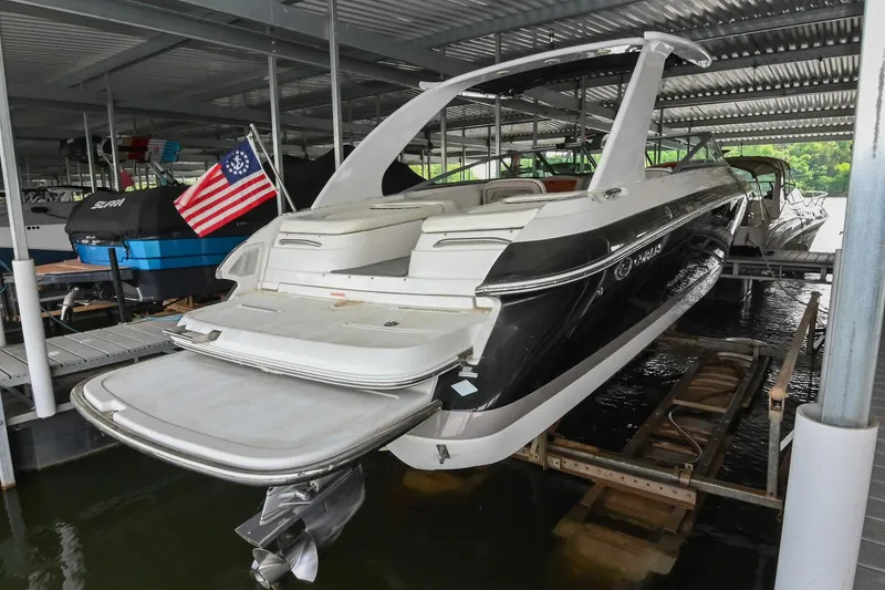 Slide: The Image of 2005 Cobalt 262 boat docked in covered marina with American flag. - 4