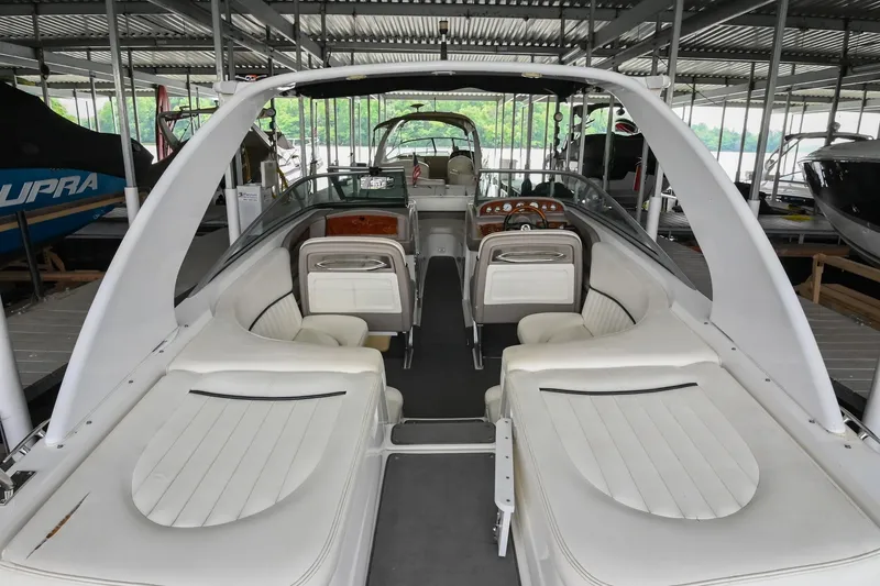 Slide: The Image of 2005 Cobalt 262 boat interior with white seating, docked under a covered marina. - 5