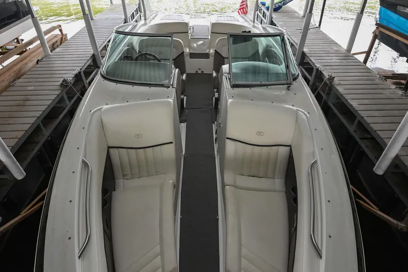 Slide: The Image of 2005 Cobalt 262 boat interior with white seating, docked in a covered area. - 6