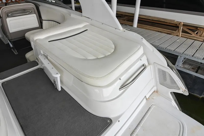 Slide: The Image of 2005 Cobalt 262 boat interior with white cushioned seating and gray flooring. - 9
