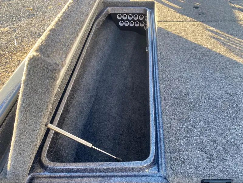 Slide: The Image of Open storage compartment in 2025 Phoenix 920 Elite boat, featuring carpeted interior and hydraulic lift. - 10