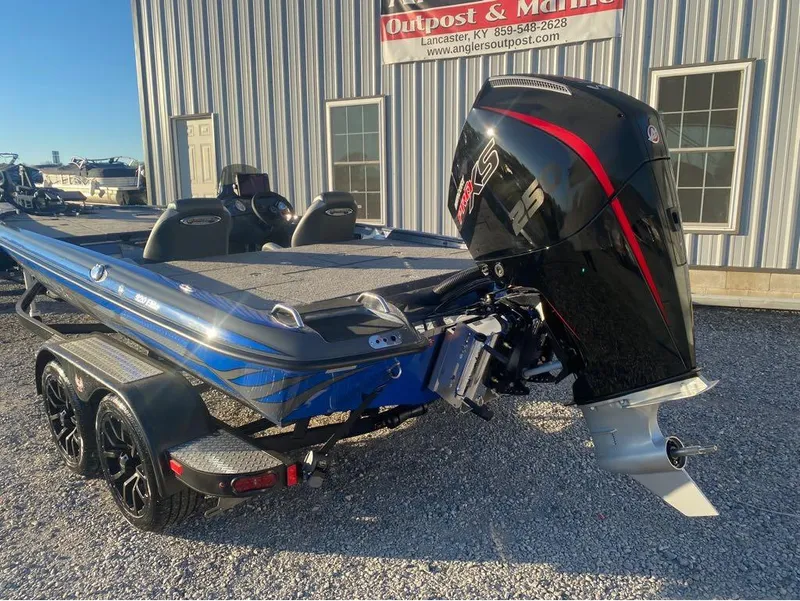Slide: The Image of 2025 Phoenix 920 Elite boat with powerful outboard motor, parked outside marine dealership. - 3