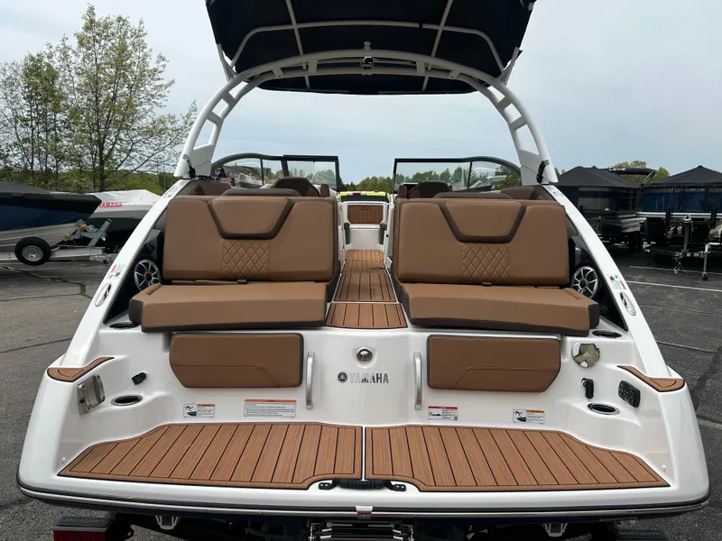 Slide: The Image of 2025 Yamaha Boats 252SE with tan seating and sleek design, docked outdoors. - 6