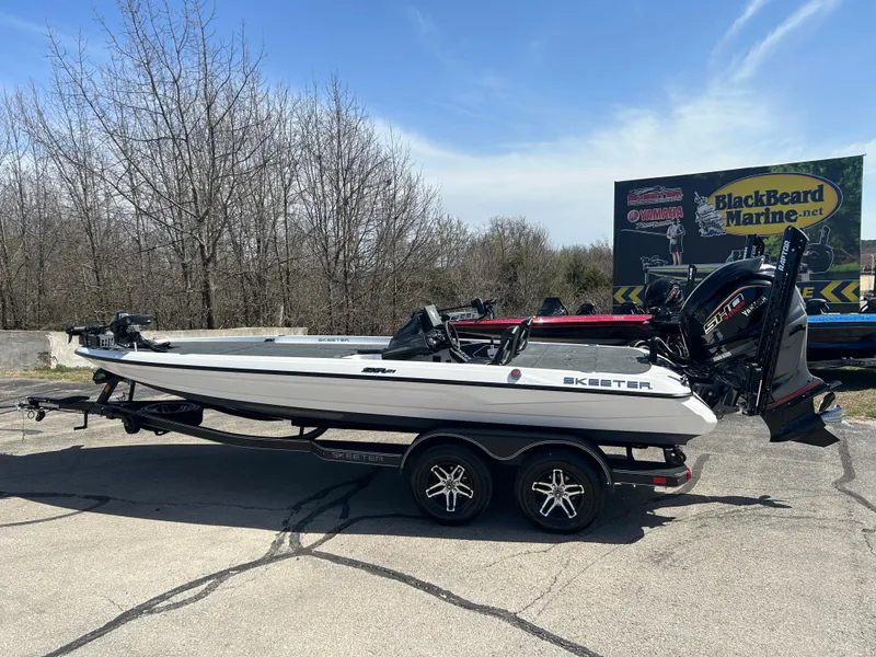 Slide: The Image of 2025 Skeeter ZXR21 boat on trailer, parked outdoors near BlackBeard Marine sign. - 1