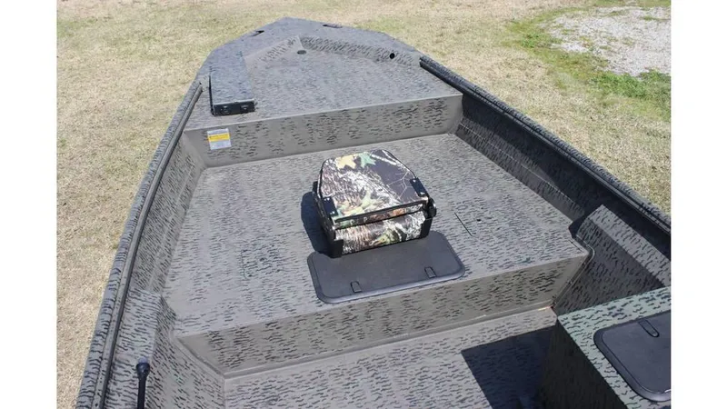 Slide: The Image of 2025 War Eagle 860LDSV Sportsman boat interior with camouflage seat on textured deck. - 1