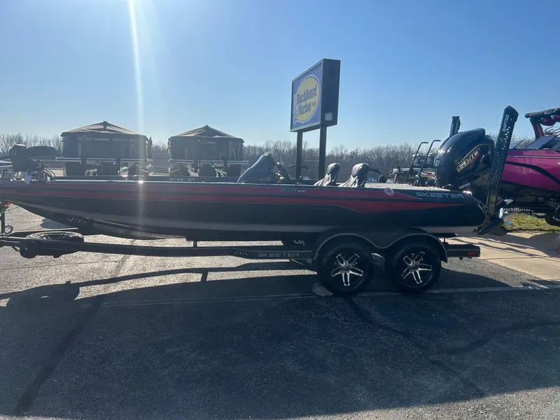 Slide: The Image of 2025 Skeeter ZXR21 boat on trailer in sunny outdoor setting. - 2