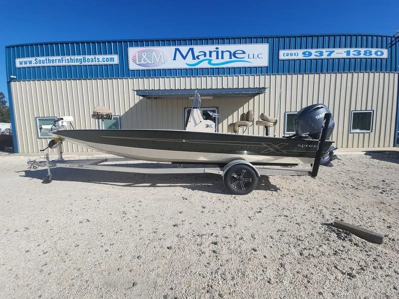 Slide: The Image of 2025 Xpress H22B boat on trailer outside marine dealership. - 0