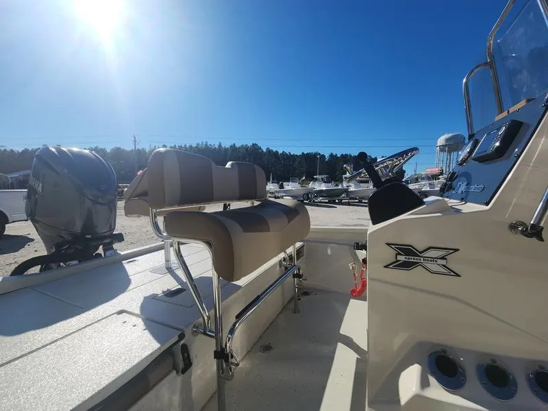 Slide: The Image of 2025 Xpress H22B boat interior with seating and controls under clear blue sky. - 14