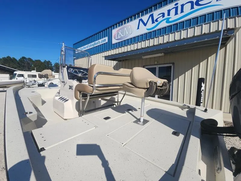Slide: The Image of 2025 Xpress H22B boat displayed outside a marine dealership. - 15