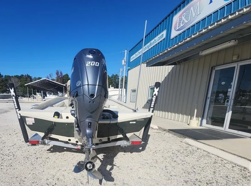 Slide: The Image of 2025 Xpress H22B boat with 200 HP engine outside dealership. - 5