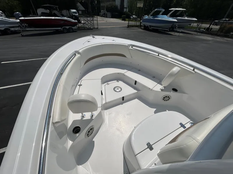 Slide: The Image of 2013 Sportsman 229 Heritage boat interior with seating and storage in a marina setting. - 11