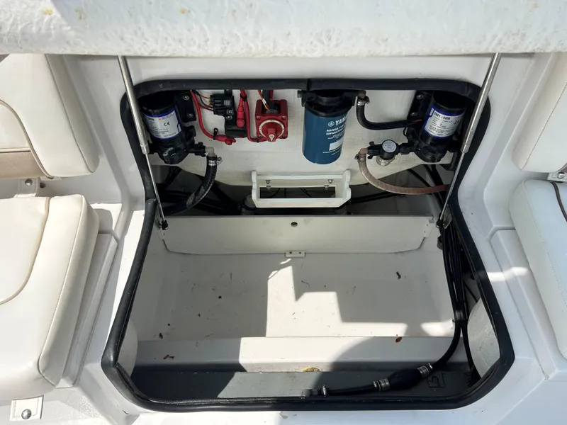 Slide: The Image of Open storage compartment in a 2013 Sportsman 229 Heritage boat, showing internal components. - 14