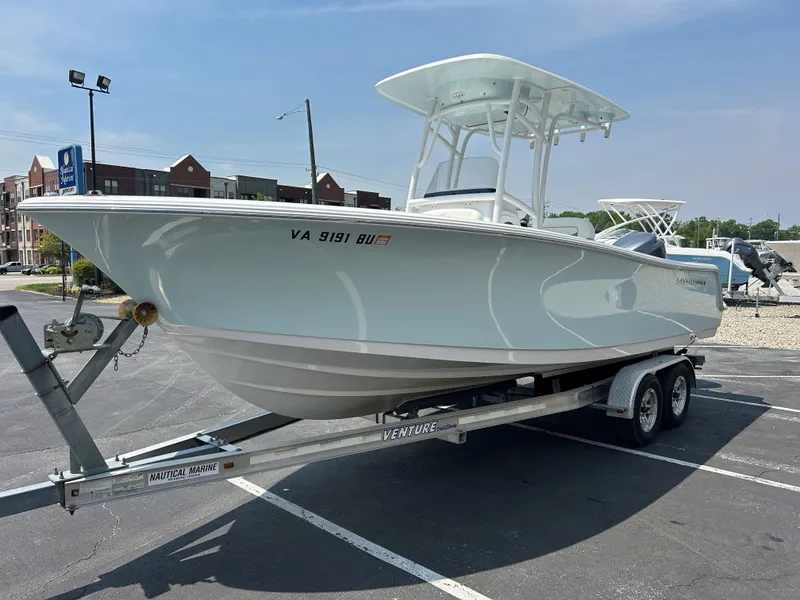 Slide: The Image of 2013 Sportsman 229 Heritage boat on trailer in parking lot, clear sky background. - 3