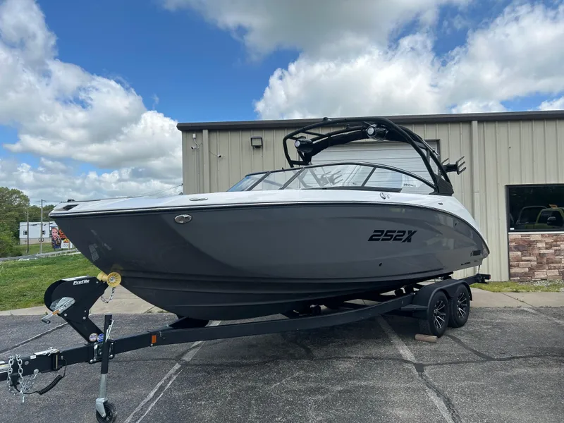 Slide: The Image of 2025 Yamaha Boats 252XE on trailer, parked outdoors under cloudy sky. - 3