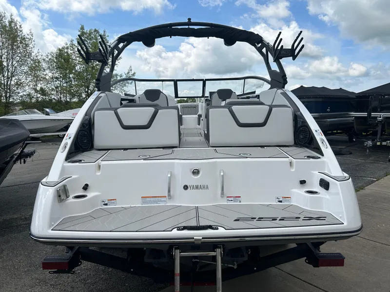 Slide: The Image of 2025 Yamaha Boats 252XE, rear view, sleek design, docked outdoors. - 5