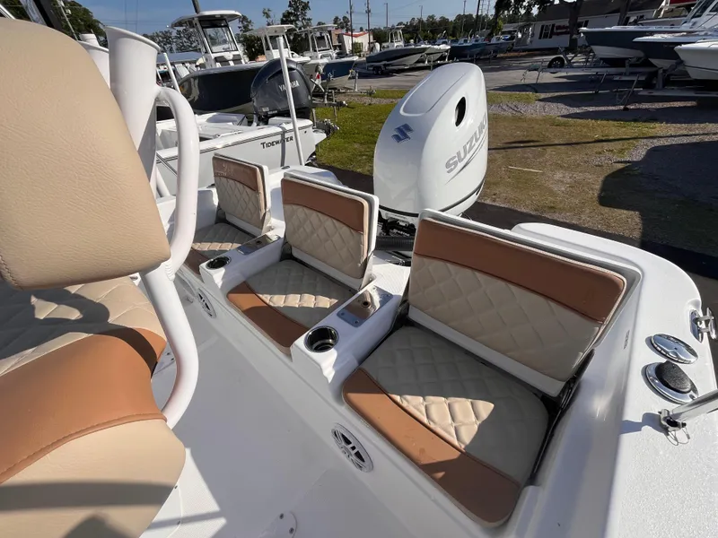 Slide: The Image of 2025 NauticStar 211 Hybrid boat interior with tan and white seating, Suzuki outboard motor. - 11
