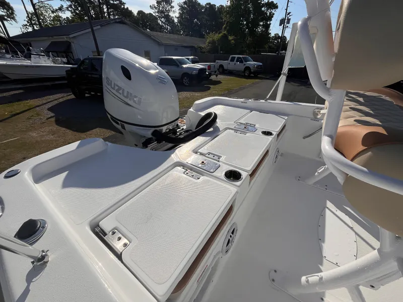 Slide: The Image of 2025 NauticStar 211 Hybrid boat with Suzuki outboard motor, docked in a sunny marina. - 3