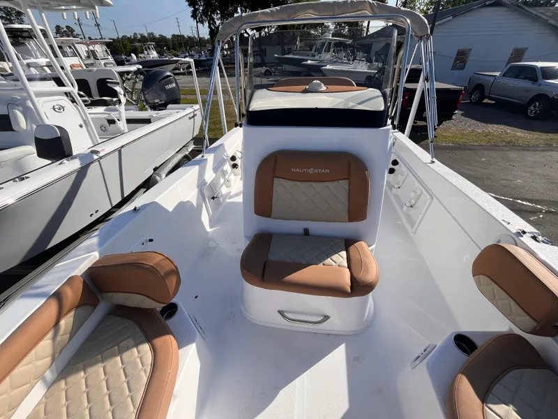 Slide: The Image of 2025 NauticStar 211 Hybrid boat interior with tan seating and console. - 8