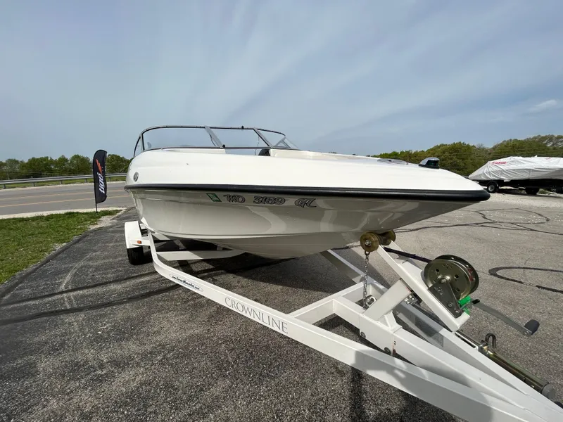 Slide: The Image of 2005 Crownline 180 BR boat on trailer, parked outdoors under a clear sky. - 6