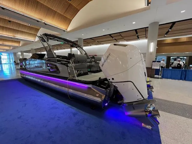 Slide: The Image of 2025 Avalon Excalibur LTD Quad Lounge boat with windshield, displayed indoors on blue carpet. - 17