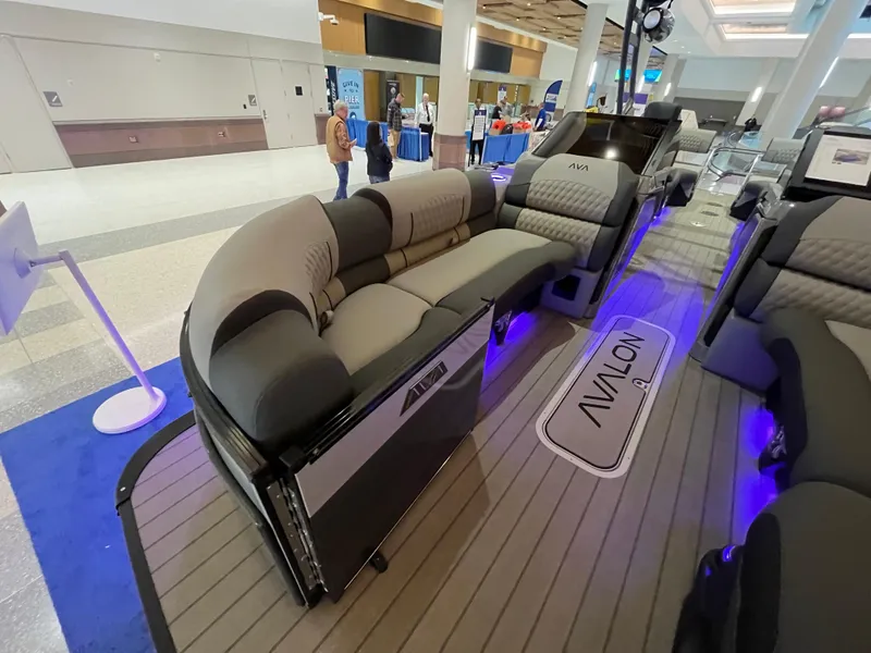Slide: The Image of 2025 Avalon Excalibur LTD Quad Lounge Windshield boat interior with luxurious seating and ambient lighting. - 22