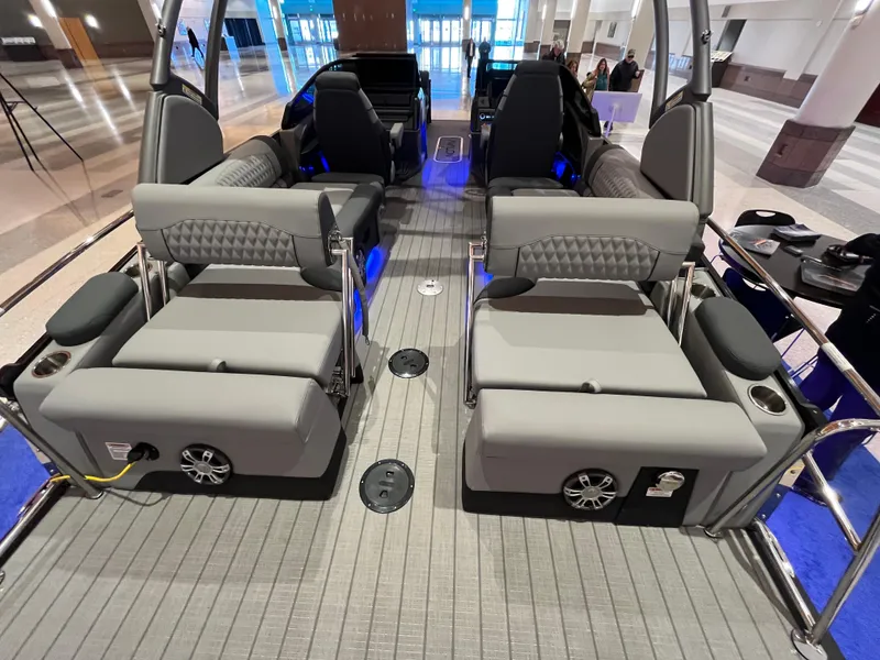 Slide: The Image of 2025 Avalon Excalibur LTD Quad Lounge Windshield boat interior with gray seating and blue lighting. - 33