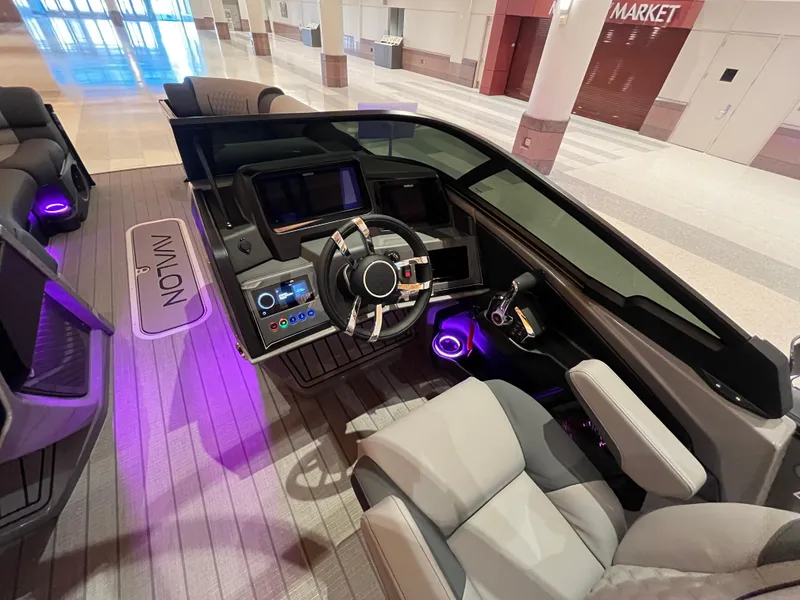Slide: The Image of 2025 Avalon Excalibur LTD Quad Lounge Windshield boat interior with modern dashboard and ambient lighting. - 41