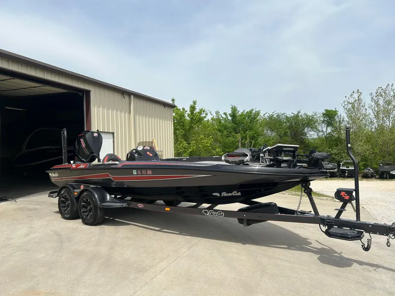 Slide: The Image of 2020 Bass Cat Lynx boat parked outside a garage on a sunny day. - 6