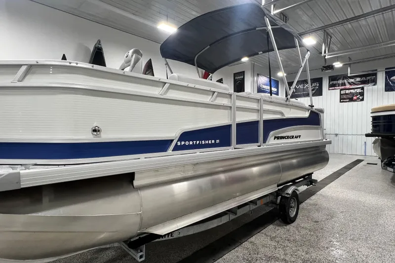 Slide: The Image of 2025 Princecraft Sportfisher 21-2S pontoon boat in showroom, side view. - 13