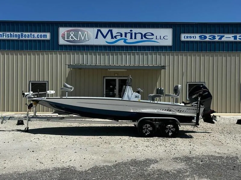 Slide: The Image of 2025 Xpress H22B boat on trailer outside L&M Marine LLC building. - 0