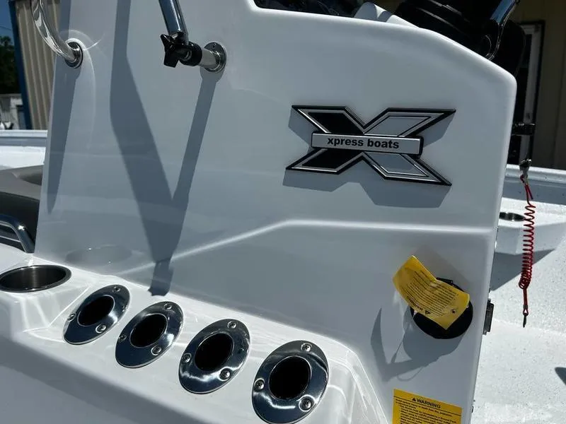 Slide: The Image of 2025 Xpress H22B boat console with logo and rod holders. - 13