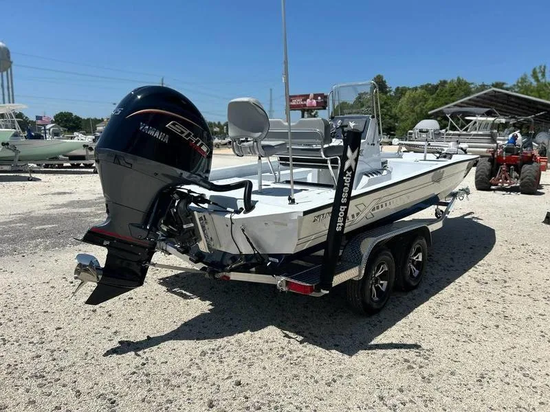 Slide: The Image of 2025 Xpress H22B boat with Yamaha engine on trailer, parked outdoors. - 4