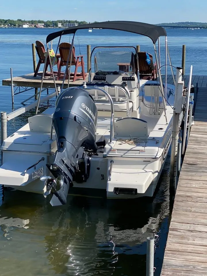 Slide: The Image of 2020 Yamaha Boats Robalo docked, featuring a Yamaha outboard motor and canopy, on a sunny day. - 4