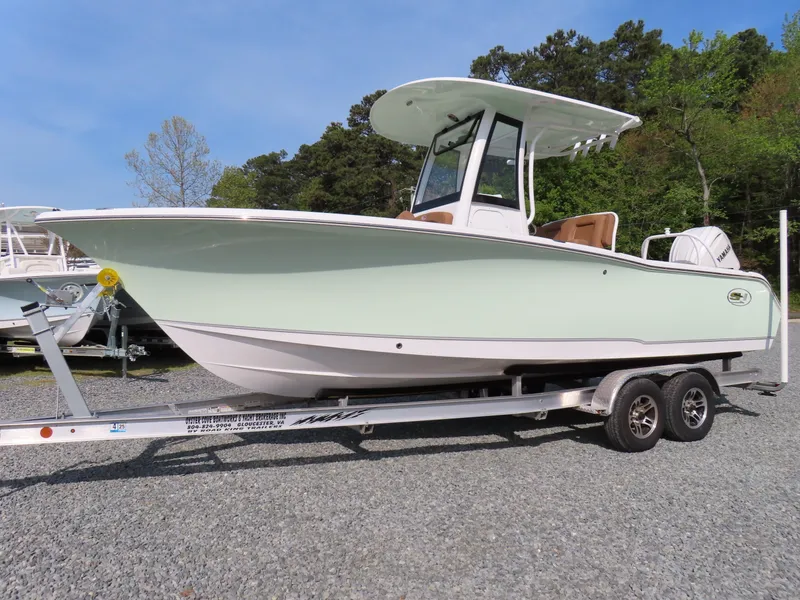 Slide: The Image of 2024 Sea Hunt Ultra 239 SE boat on a trailer, parked outdoors. - 0