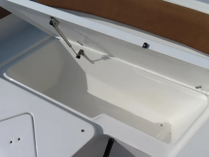 Slide: The Image of 2024 Sea Hunt Ultra 239 SE storage compartment with open lid, showcasing spacious interior. - 11