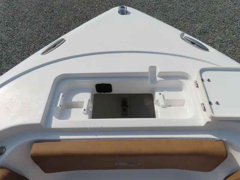 Slide: The Image of 2024 Sea Hunt Ultra 239 SE boat bow storage compartment with cushioned seating. - 13