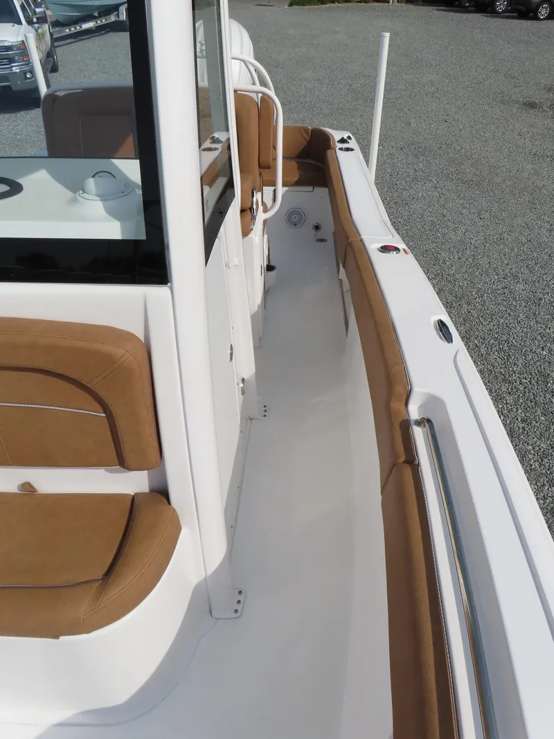 Slide: The Image of 2024 Sea Hunt Ultra 239 SE boat with tan seating and sleek white deck design. - 16