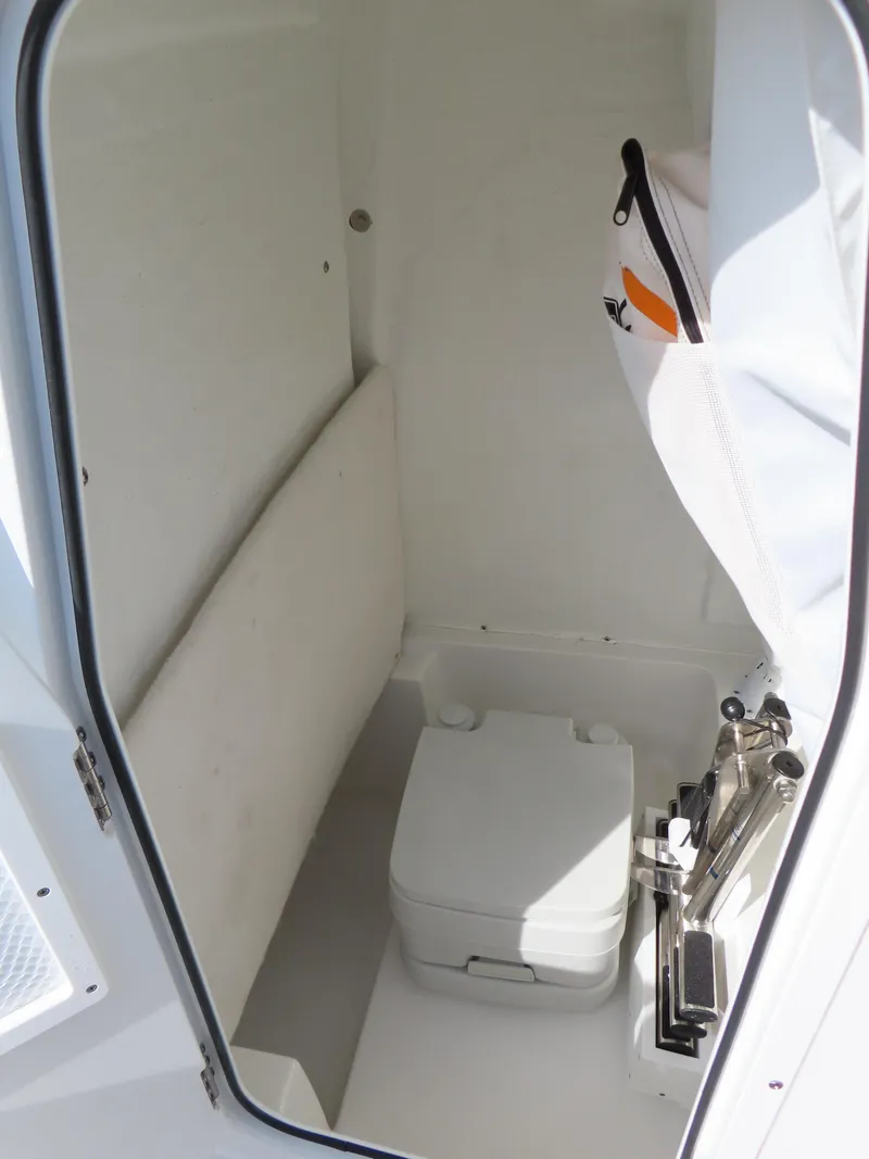 Slide: The Image of 2024 Sea Hunt Ultra 239 SE boat interior with compact marine toilet. - 20