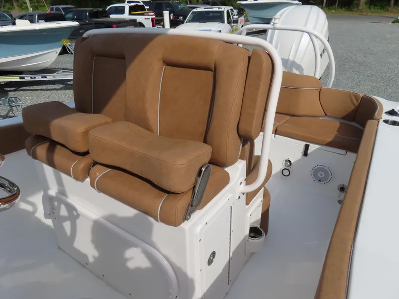 Slide: The Image of 2024 Sea Hunt Ultra 239 SE boat interior with tan cushioned seating. - 21