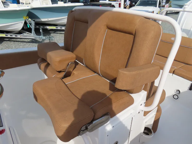Slide: The Image of 2024 Sea Hunt Ultra 239 SE boat seat with brown upholstery and armrests. - 23