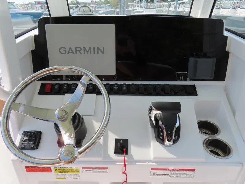 Slide: The Image of 2024 Sea Hunt Ultra 239 SE helm with Garmin navigation system and modern controls. - 24