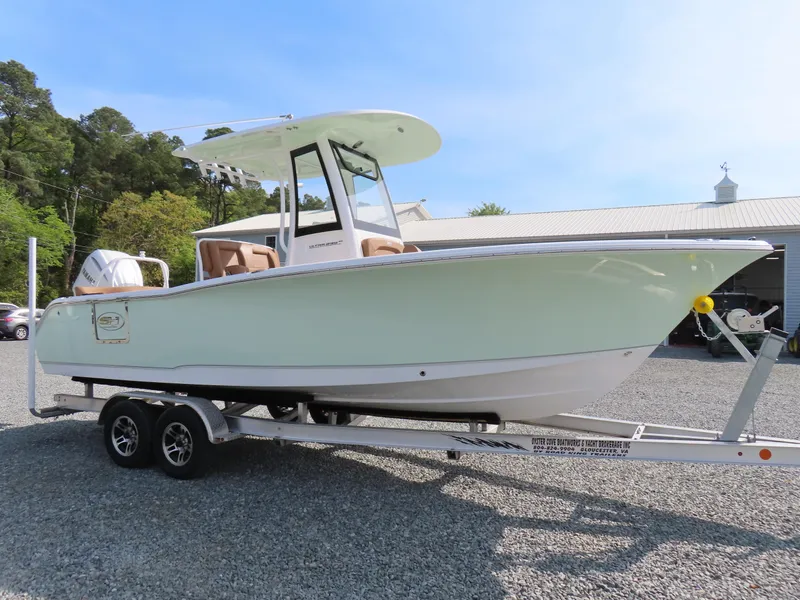 Slide: The Image of 2024 Sea Hunt Ultra 239 SE boat on a trailer, parked outdoors. - 3