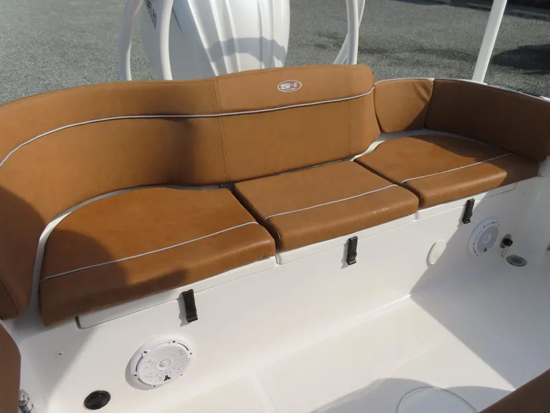Slide: The Image of 2024 Sea Hunt Ultra 239 SE boat with brown cushioned seating and white deck. - 34