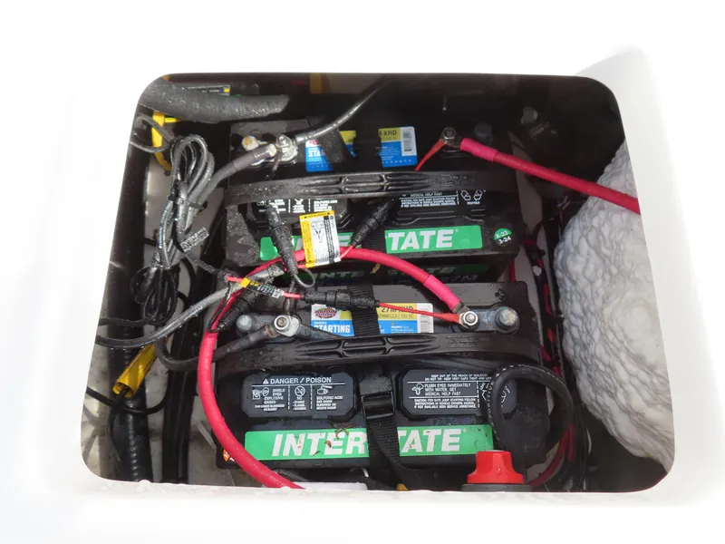 Slide: The Image of 2024 Sea Hunt Ultra 239 SE boat battery compartment with Interstate batteries and wiring. - 37
