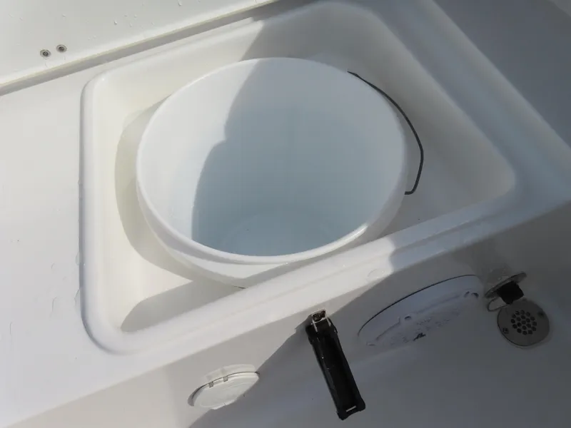 Slide: The Image of 2024 Sea Hunt Ultra 239 SE boat with built-in storage compartment and white bucket. - 39